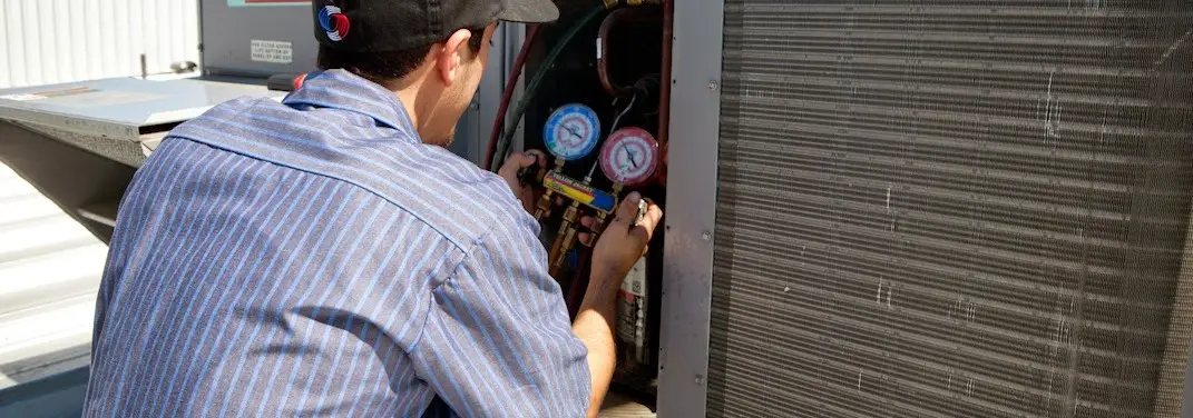 HVAC technician servicing a condenser unit in Winter Park